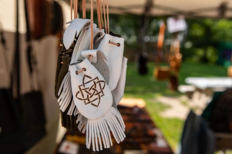 A white leather purse hanging from a string.