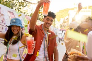 A group of people holding up drinks and food.
